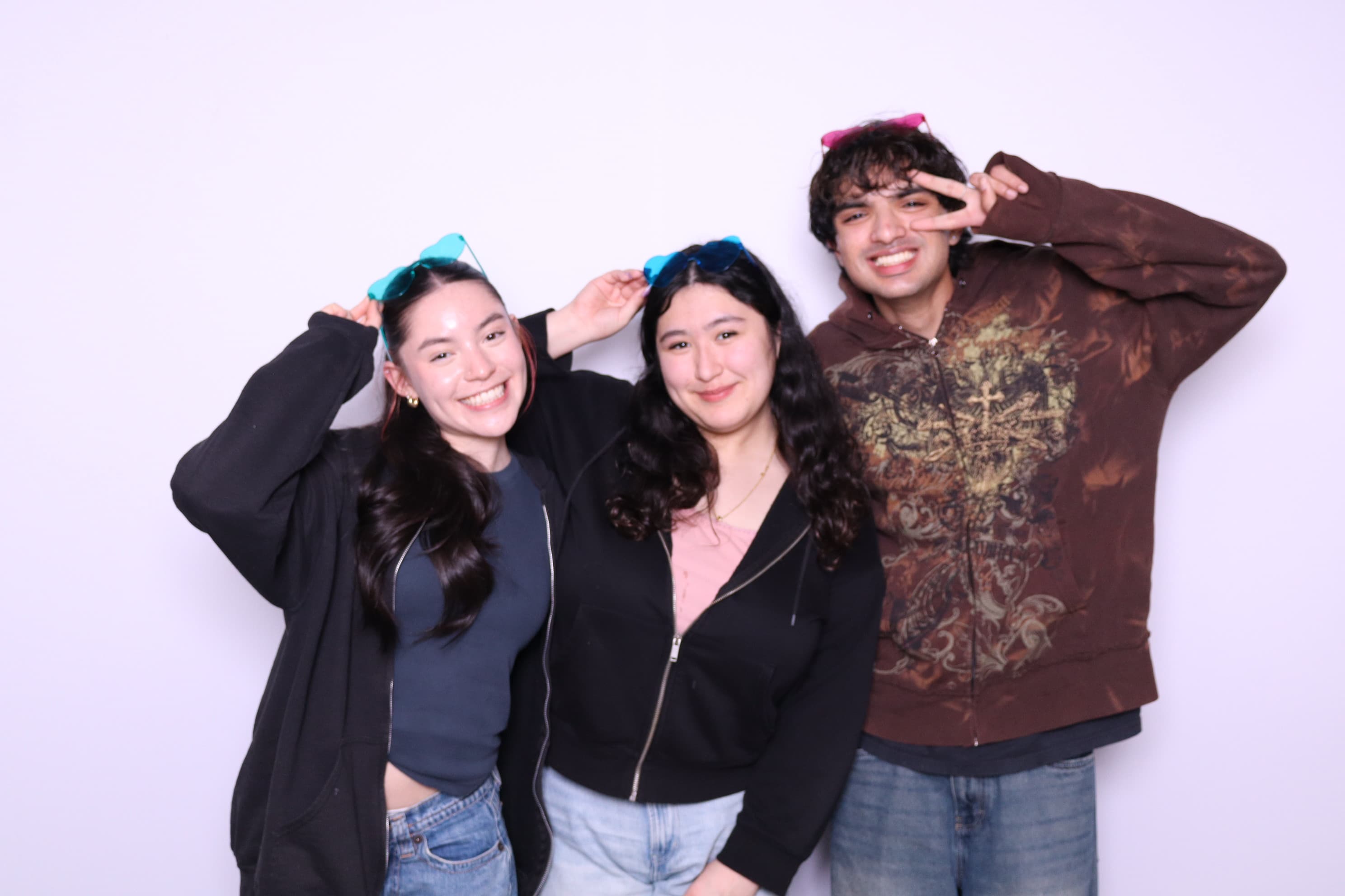 Trio of friends with sunglasses at photo booth gathering
