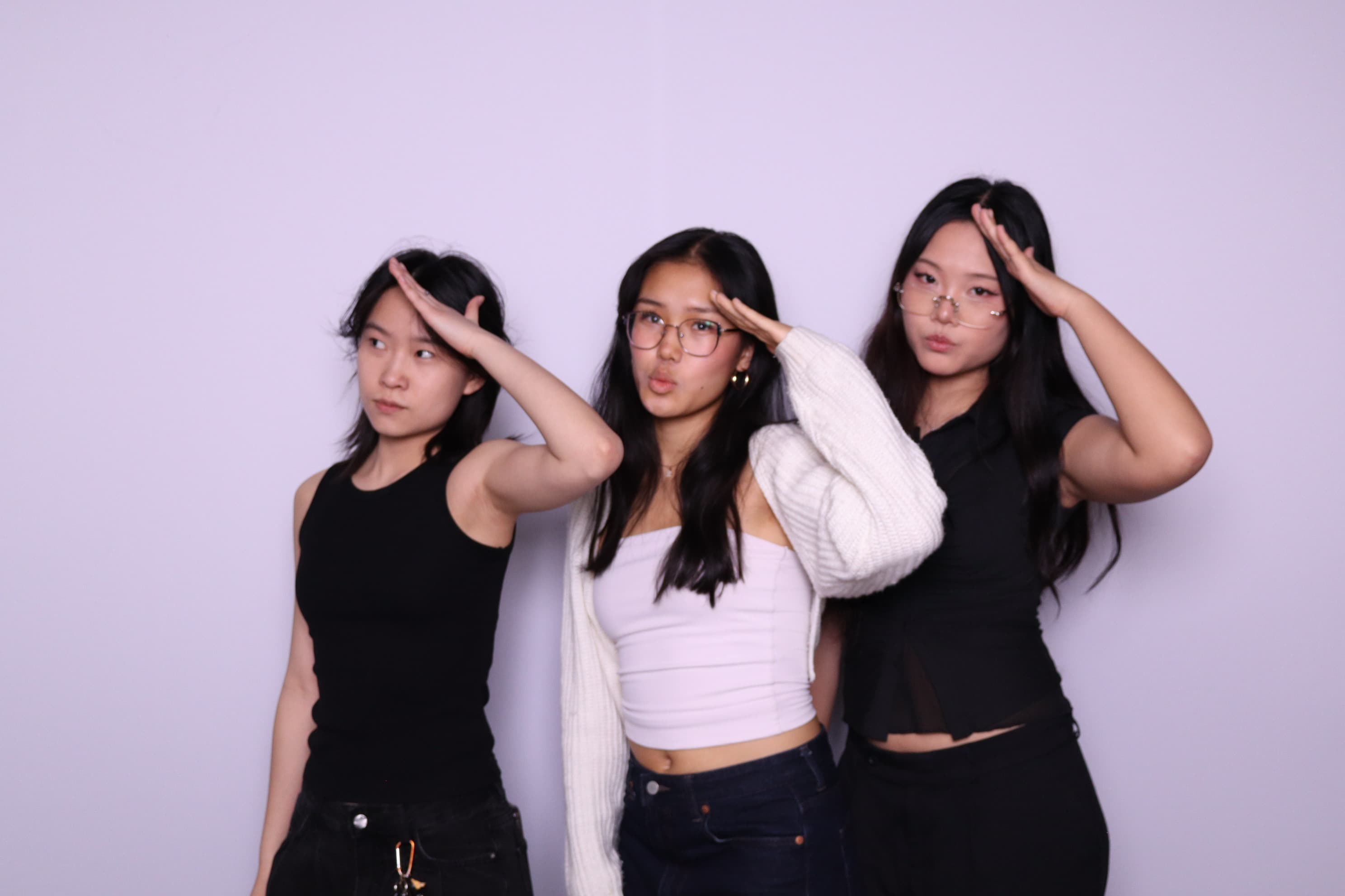 Three friends doing salute pose at photo booth event