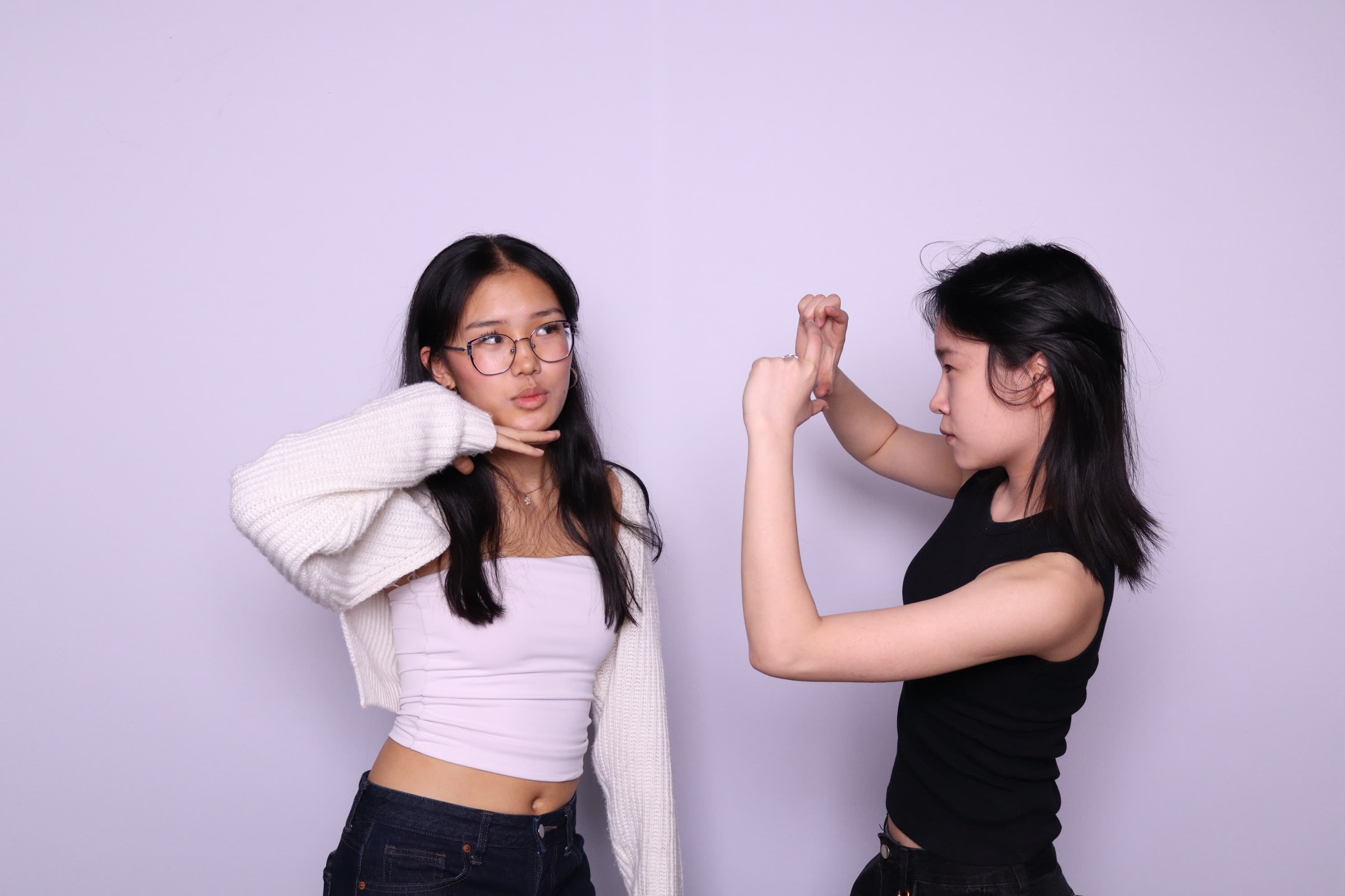 Two friends doing playful poses at photo booth event