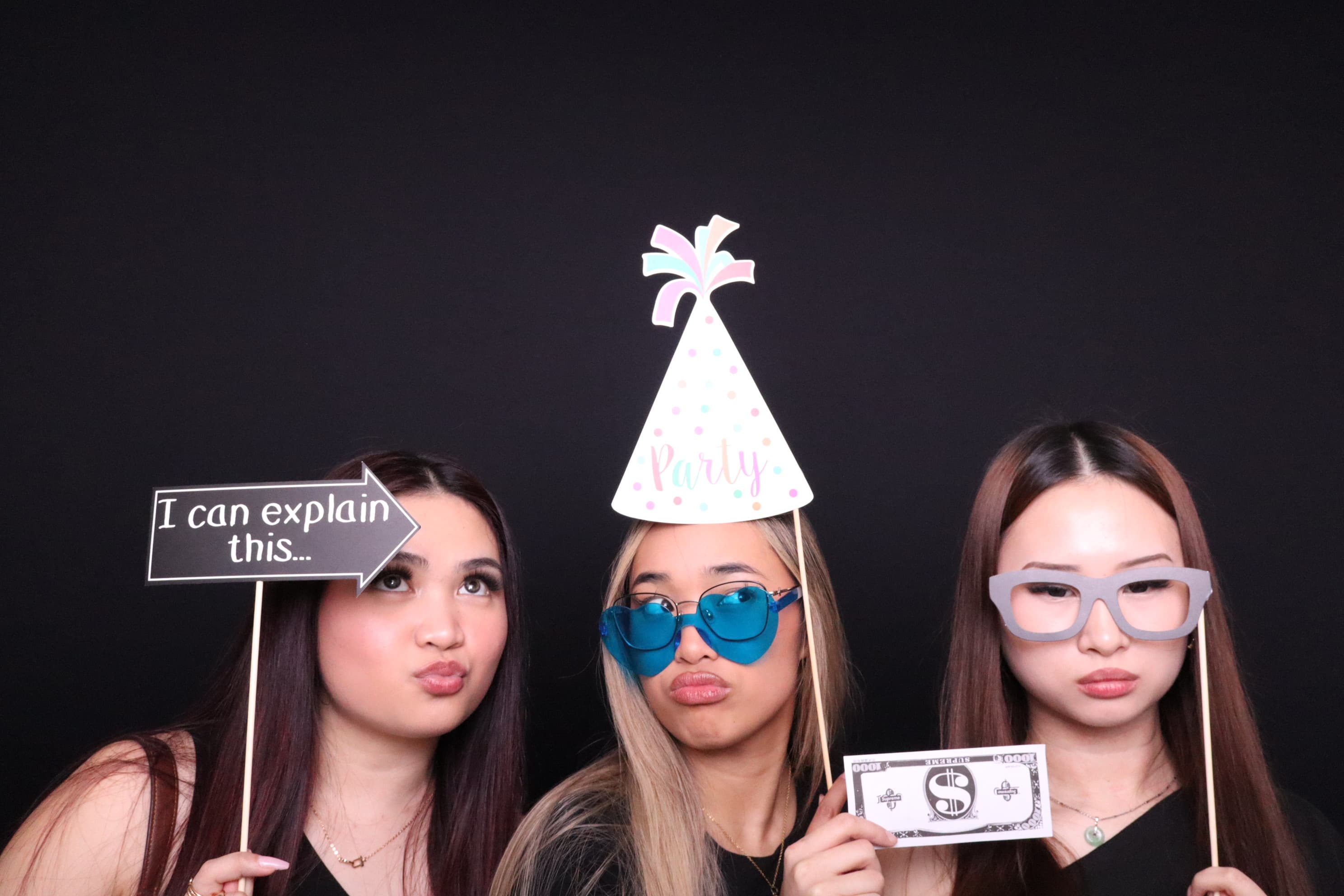 Girls with party hats and funny props at photo booth Vancouver