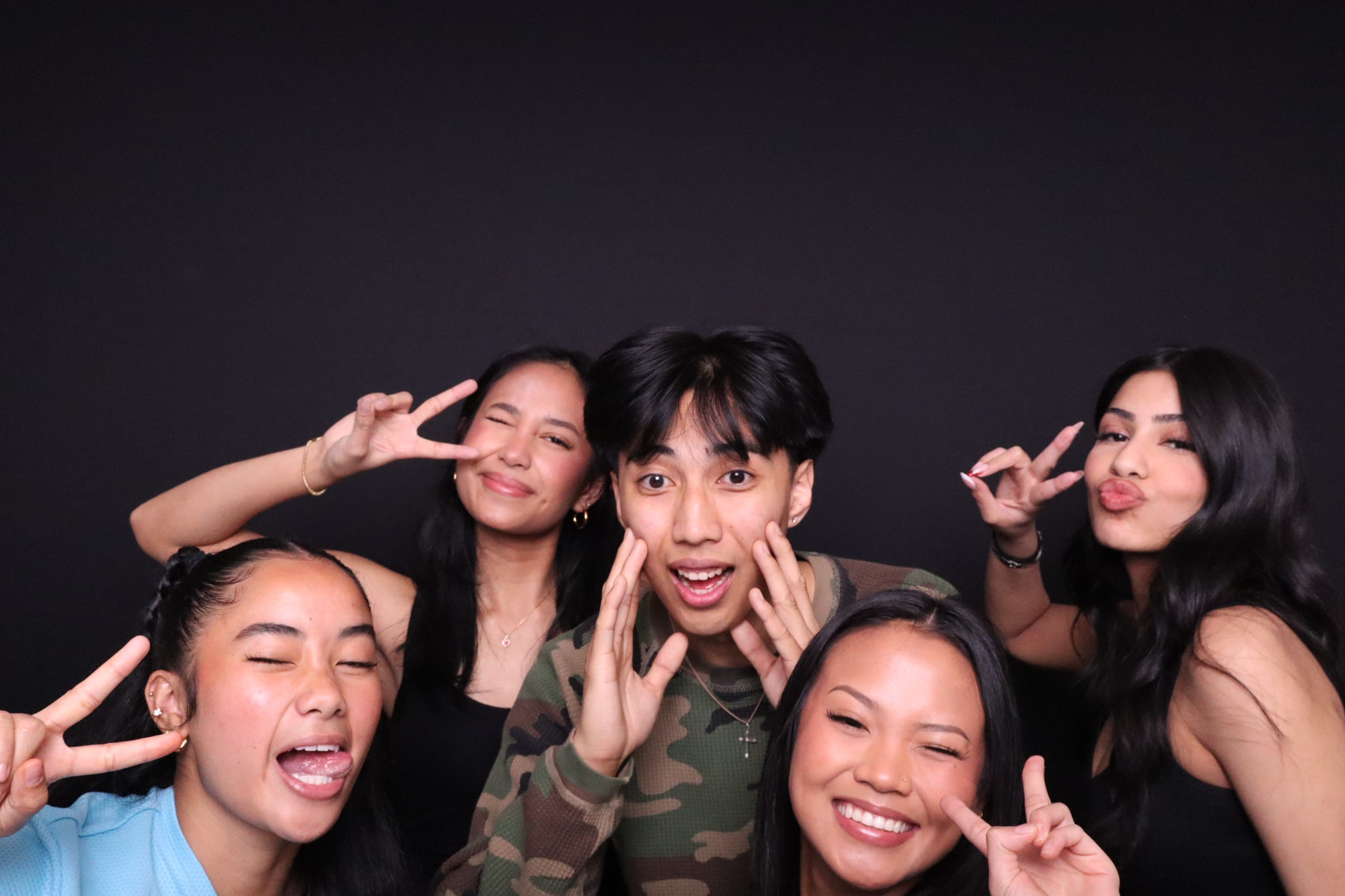 Group throwing peace signs at photo booth birthday party Vancouver